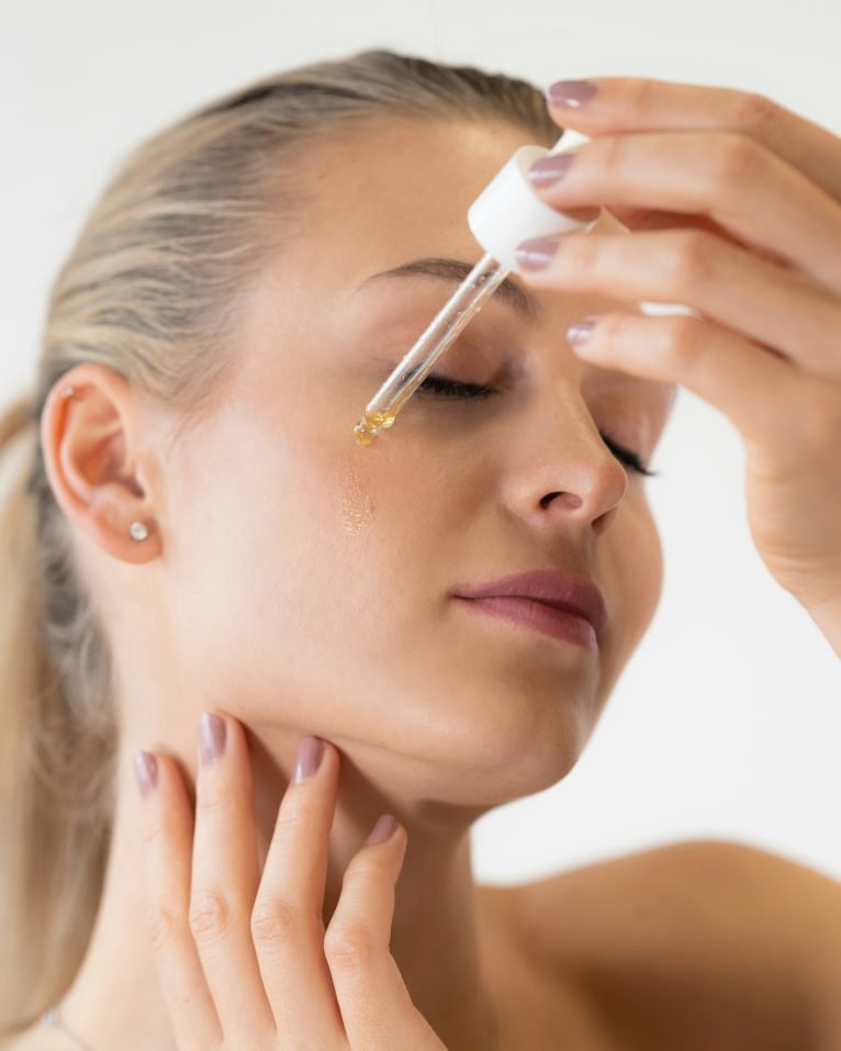 Woman applying facial oil with a dropper